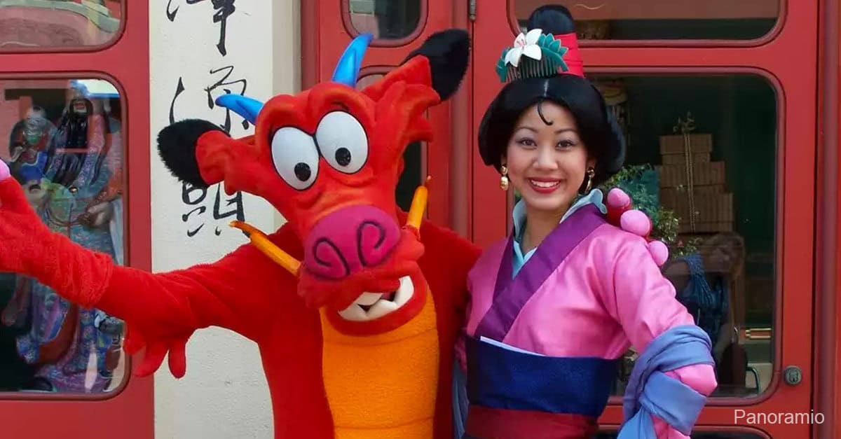 Mushu and Mulan beam together outdoors, bringing Disney’s beloved characters to life for unforgettable guest moments.