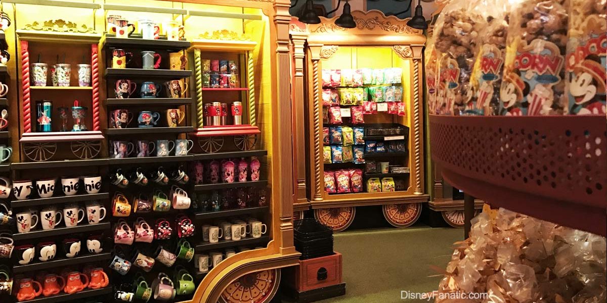 Disney Parks shelves display vibrant character mugs, sweet treats, and snacks inside a lively, immersive souvenir shop.