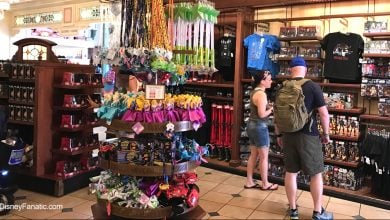 Guests exploring shelves filled with Disney toys, apparel, and souvenirs in a vibrant Disney Parks merchandise shop.