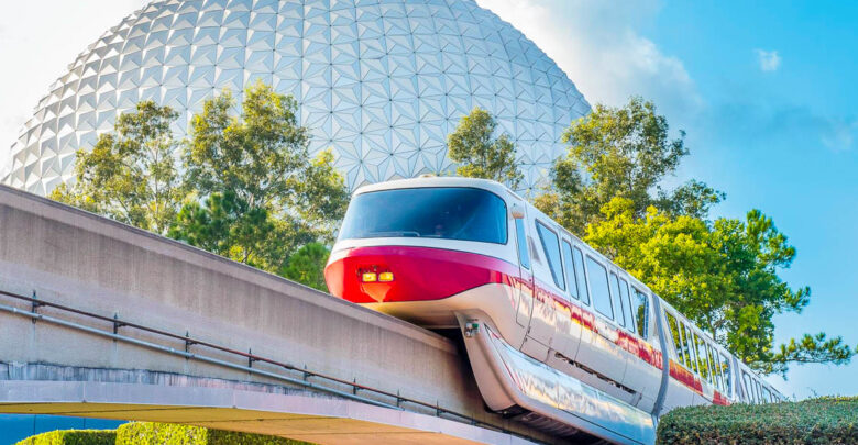 The Walt Disney World monorail glides past Epcot’s iconic Spaceship Earth under a bright Florida sky, framed by lush greenery.