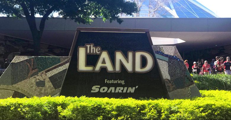 The Land Pavilion entrance sign with Soarin’ highlighted at Epcot, surrounded by lush landscaping and visiting guests.