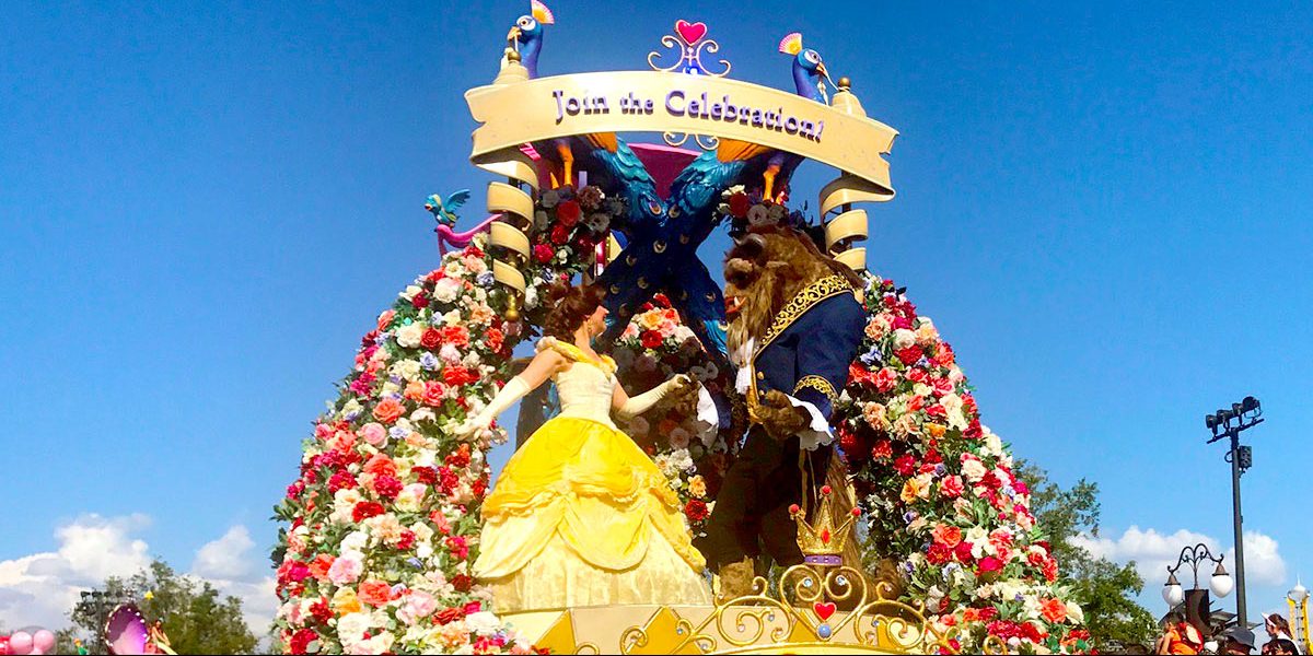 Belle and Beast waltz amid roses atop a colorful Disney World parade float, beneath a “Join the Celebration!” sign.