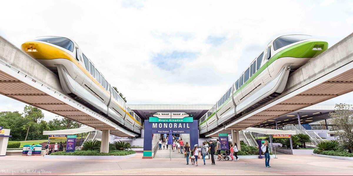 Monorail trains glide above crowds at the Magic Kingdom Monorail station, capturing that iconic Walt Disney World experience.