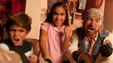 Kids and a pirate from Pirate Adventure Show strike playful, fierce poses in an energetic, themed entertainment setting.