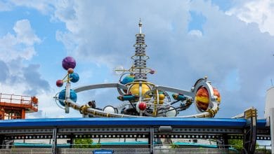 Whimsical planet sculpture with vibrant rings and orbiting orbs on display at Universal Studios’ sci-fi themed zone.