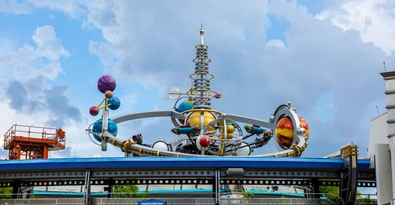 Whimsical planet sculpture with vibrant rings and orbiting orbs on display at Universal Studios’ sci-fi themed zone.