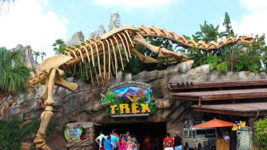 A towering dinosaur skeleton greets guests at the entrance of T-Rex Cafe, where visitors gather for prehistoric-themed fun.