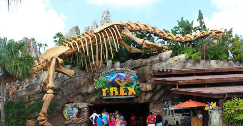 A towering dinosaur skeleton greets guests at the entrance of T-Rex Cafe, where visitors gather for prehistoric-themed fun.