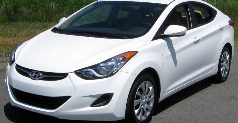 A white Hyundai sedan styled like Disney transport is parked roadside, surrounded by lush greenery like at a theme park resort.