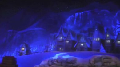 Magical winter village lit by twinkling blue lights, cozy cabins aglow, with snowy mountains creating an enchanting backdrop.