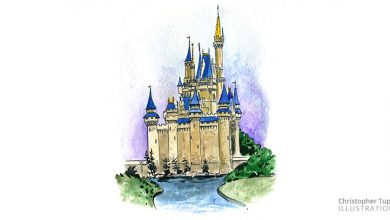 Storybook castle with blue rooftops, nestled by water and lush gardens, evoking the magic of a beloved theme park icon.