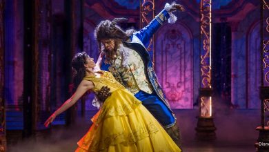 Belle twirls in her signature yellow ballgown with the Beast in a lavishly decorated ballroom, evoking Disney Parks magic.