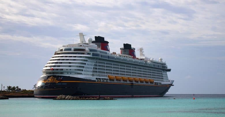 A vibrant cruise liner docks beside a lush island paradise, inviting guests to explore sparkling waters and sunny adventure.