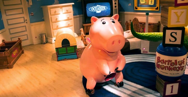 Hamm the piggy bank from Toy Story stands in Andy’s vibrant, toy-filled bedroom at Pixar Pier.