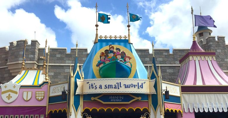 The whimsical entrance to "it's a small world" in Fantasyland, with vibrant decor and festive flags beneath a partly cloudy sky.