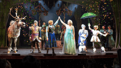 A group of performers for the Broadway-style Frozen show on the Disney Wonder take a bow on stage after a theatrical performance.