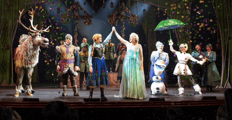 A group of performers for the Broadway-style Frozen show on the Disney Wonder take a bow on stage after a theatrical performance.