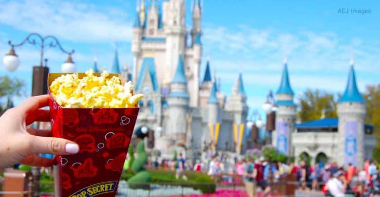 Popcorn in hand with Cinderella Castle behind, surrounded by excited Disney World guests on a sun-filled park day.