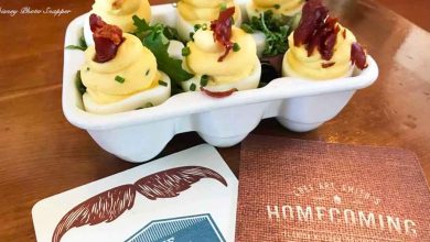 A festive tray of deviled eggs with bacon and chives, ready for your next big theme park party at a lively attractions table.