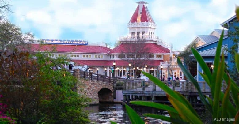 Vibrant riverfront at Disney’s Port Orleans Resort, featuring the Sassagoula Steamboat Co. near a charming bridge.