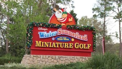 Disney's Winter Summerland Miniature Golf sign shines with holiday cheer, decked out in colorful Christmas decorations.