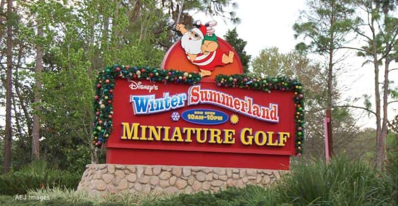Disney's Winter Summerland Miniature Golf sign shines with holiday cheer, decked out in colorful Christmas decorations.