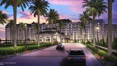 Cars roll up to a grand Disney resort, palm-lined and glowing at sunset—an epic welcome after a magical day at EPCOT.