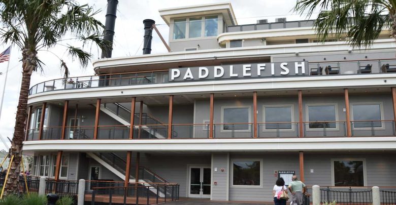 Paddlefish at Disney Springs with its bold sign, lively deck railings, and guests strolling along the waterfront entrance.