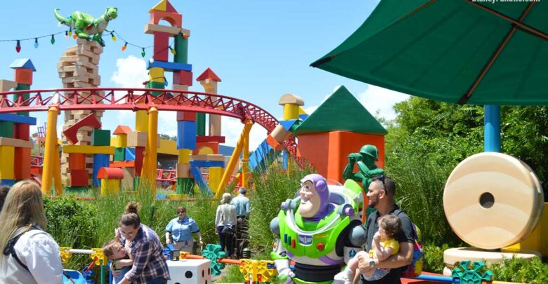 Buzz Lightyear and Rex welcome guests to Toy Story Land, surrounded by giant colorful blocks and playful themed decor.
