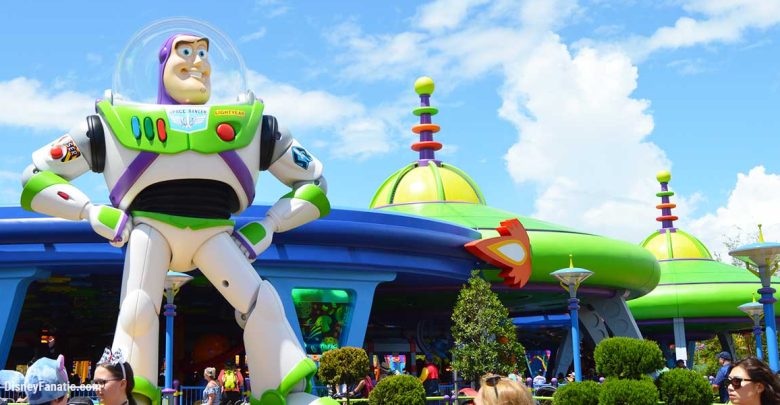 Buzz Lightyear greets guests outside Toy Story Land’s vibrant, space-themed attraction on a bright, sunny day.