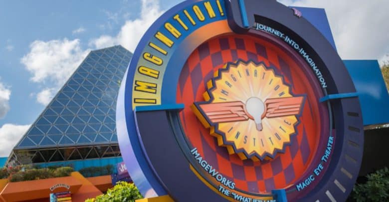 The sign for "Journey into Imagination" at the theme park pops with colorful designs and geometric shapes. A futuristic building with a glass pyramid structure gleams in the background against a blue sky—a hidden gem often overlooked in lists of rides to skip at Walt Disney World.
