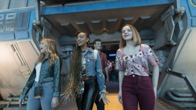 Four people walk excitedly out of a futuristic, sci-fi themed building with blue and gray walls, smiling as if they just used top Hollywood Studios ride strategies to enjoy an amazing amusement park attraction.