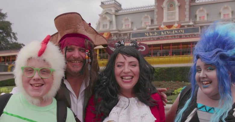 Four people in colorful costumes, including a pirate, a chicken, and a character with bright blue hair, stand smiling in front of the Magic Kingdom entrance at Disney World—ready for fun while following Walt Disney World rules.