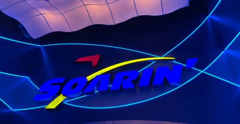 The image features the Soarin' logo in blue, red, and yellow against a dark backdrop adorned with blue neon lines and geometric patterns, reminiscent of EPCOT's futuristic charm.