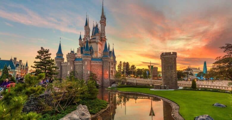 Enchanted castle glowing at dusk, mirrored in a tranquil lagoon, surrounded by manicured lawns and magical woodlands.