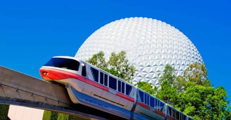 The Walt Disney World monorail glides past Epcot’s iconic Spaceship Earth, set against a flawless blue Florida sky.