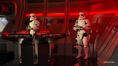 Stormtroopers monitor control panels in a glowing red Star Wars spaceship, ensuring galactic order like Disney Park security.