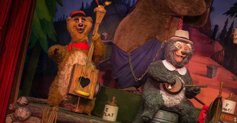 The Country Bears perform lively music on their vibrant stage, surrounded by whimsical forest-themed scenery.