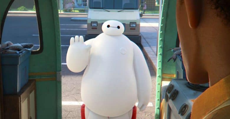 Baymax enthusiastically waves hello outside a food truck, as seen from the interior during Disney park festivities.