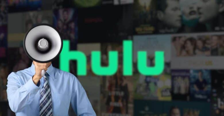 A megaphone-headed mascot stands before a blurred Hulu marquee and vibrant TV show banners, channeling theme park flair.