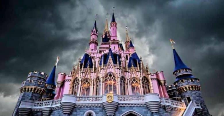 A majestic castle with tall spires and intricate details, illuminated under dramatic dark clouds. The castle is primarily pink with blue rooftops and flags, creating a striking contrast with the stormy sky.
