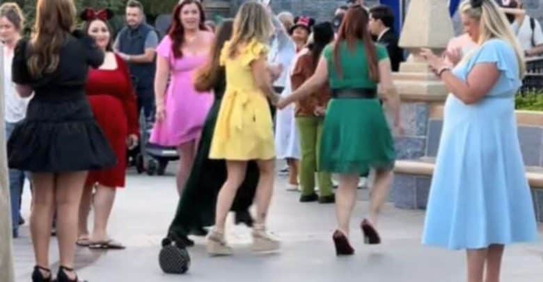 Women in matching Disney princess outfits at Disneyland Park.