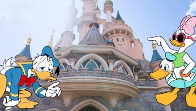 Donald Duck and Daisy Duck stand in front of a fairytale castle. Donald appears discontented with his hands on his hip, while Daisy, wearing sunglasses and a bow, points joyfully at something. The sky is clear and bright, adding to the cheerful atmosphere despite recent Disney closures.