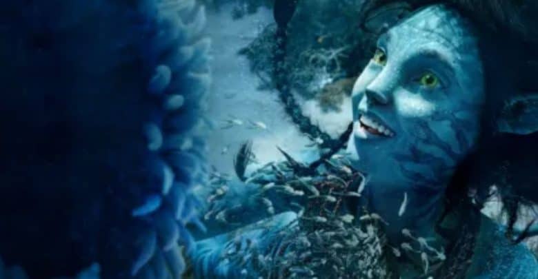 A blue-skinned humanoid creature with scales is underwater in 'Avatar: The Way of Water.'