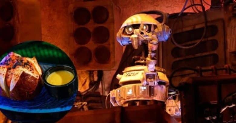 A robot in a sci-fi setting with retro-style gears stands beside a circular image of a food dish, featuring a bread roll with dipping sauce. The scene is lit with warm, colorful lighting.