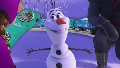 Animated scene featuring a joyful snowman with a carrot nose, surrounded by snowy landscapes. A toy train and snowflakes set a playful mood. A green toy box labeled "Frozen" is partially visible on the left.