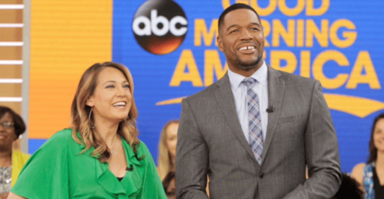Two television hosts, a woman in a green dress and a man in a gray suit, smiling and interacting on the set of a morning show with audience in the background during Rob Marciano's segment.