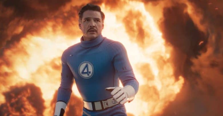 A man in a blue superhero suit with a number 4 emblem stands in front of a massive fiery explosion, looking intensely ahead with a determined expression, reminiscent of the heroes Kevin Feige talks about in Fantastic 4 discussions.