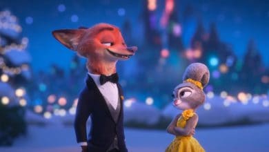 Nick Wilde in a tuxedo and Juddy Hopps in a yellow dress stand together outdoors at night, smiling at each other, with blurred festive lights and a castle in the background.