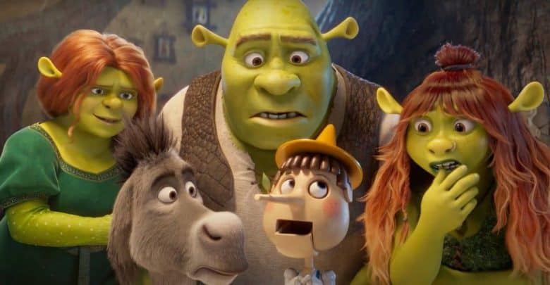 Five animated characters, including green ogres, a donkey, and a wooden puppet, look surprised and curious while standing close together, with a blurry forest background.